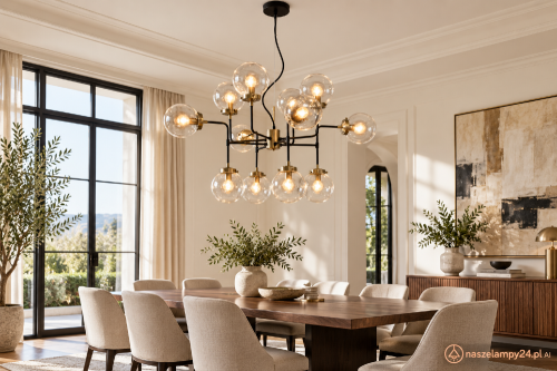 Lampa wisząca ODELIA Italux V1009-12 ma 12 przezroczystych szklanych kul i czarną konstrukcję z detalami w kolorze antycznego brązu. Średnica 100 cm sprawia, że dobrze prezentuje się nad dużym stołem w jadalni.