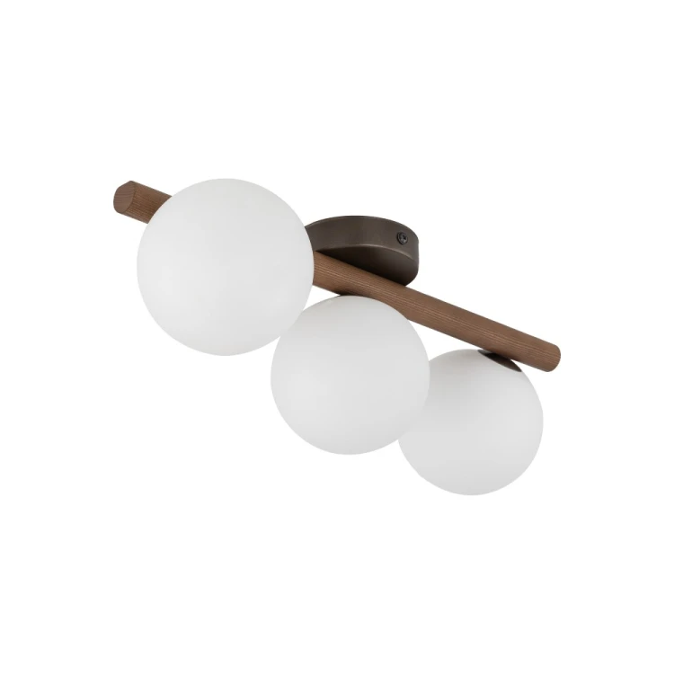 Lampa ESTERA WOOD 3×G9 sprawdzi się na suficie lub ścianie w sypialni i przedpokoju. Ciemne drewno w odcieniu orzecha kontrastuje z trzema białymi kloszami. Model TK-Lighting 10269 ma stopień ochrony IP20.