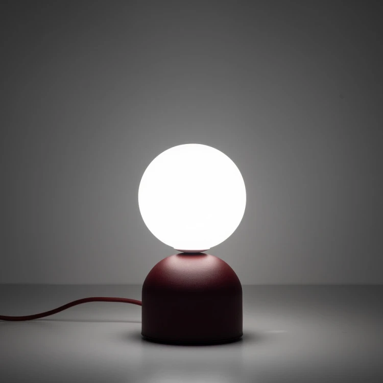 MIKI TK-Lighting 16216 to niewielka lampka na stolik nocny lub komodę. Burgundowa podstawa i biały klosz kulisty podkreślają nowoczesny styl wnętrza. Wymiary 12 × 12 × 21 cm, oprawka G9, maks. 8 W LED, IP20.