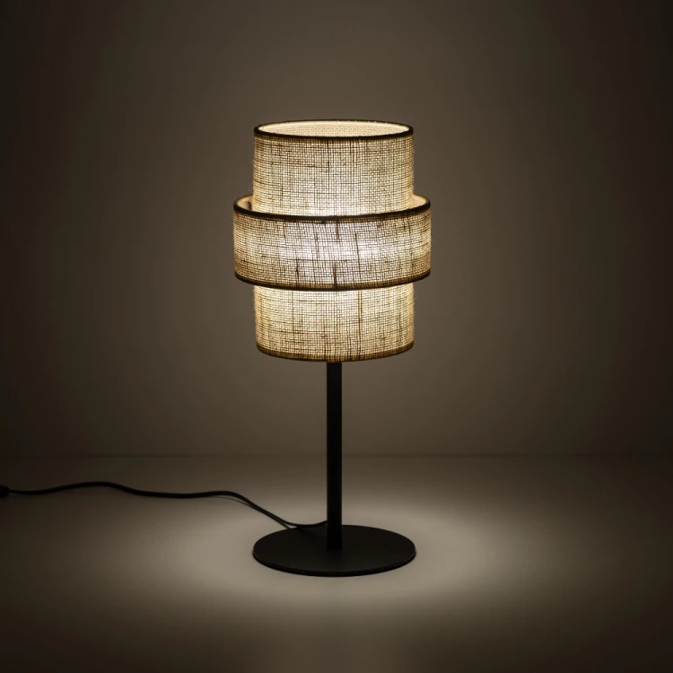 CALISTO TK-Lighting to lampka stołowa w stylu boho, która ozdobi salon lub sypialnię. Jutowy abażur wyróżnia się dekoracyjną formą, a czarny stelaż podkreśla jego naturalny kolor. 1×E27, maks. 15 W LED, IP20.