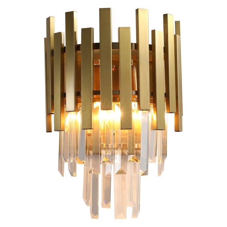 Milagro ASPEN ML5998 to stylowy kinkiet wykonany z metalu i kryształów. Złote wykończenie oraz efektowne refleksy światła sprawiają, że lampa doskonale prezentuje się w eleganckich wnętrzach glamour i modern classic.