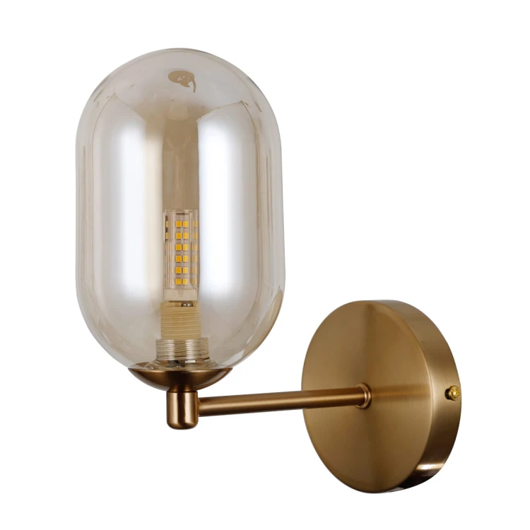 Kinkiet PERANO Italux WL-4215-1A-HBR łączy mosiężną armaturę z podłużnym bursztynowym kloszem ze szkła. Ma 23 cm wysokości, 23 cm szerokości, 10 cm głębokości i oprawkę G9. Idealny do salonu lub sypialni.