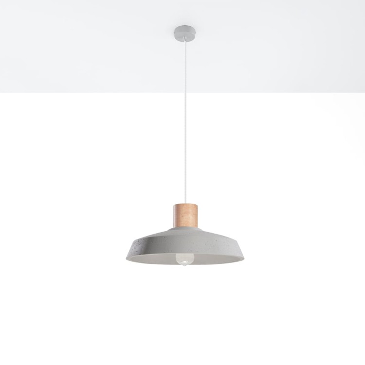 Betonowa lampa wisząca AFRA w stylu industrialnym zawieszona nad stołem. Surowy klosz z betonu i drewniany detal tworzą minimalistyczną kompozycję. Szara kolorystyka i transparentny przewód doskonale uzupełniają nowoczesne i loftowe wnętrza