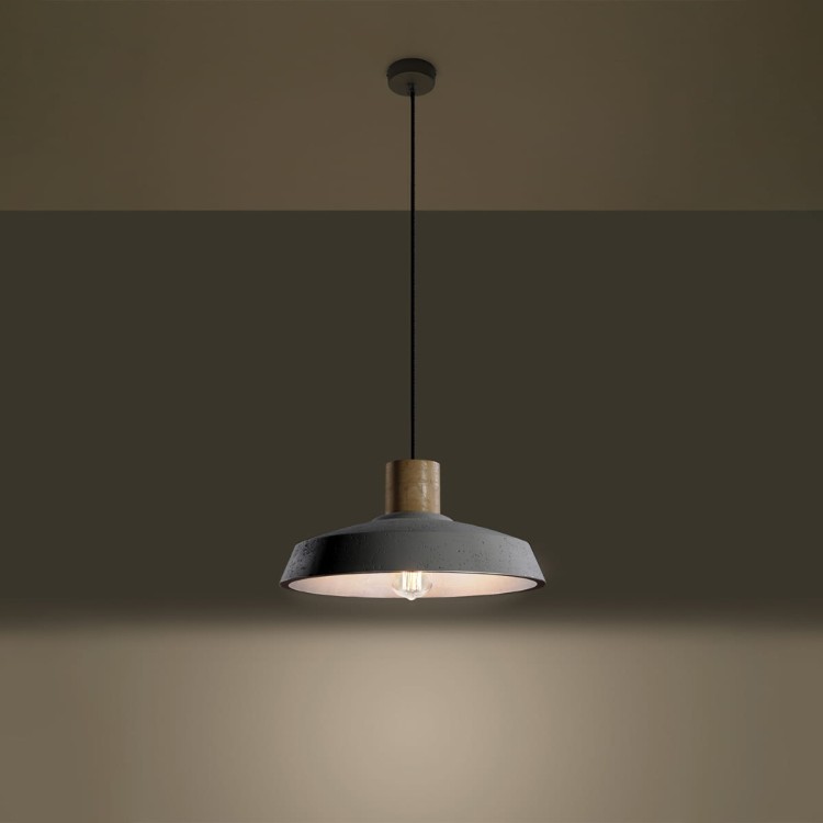 Betonowa lampa wisząca AFRA w stylu industrialnym zawieszona nad stołem. Surowy klosz z betonu i drewniany detal tworzą minimalistyczną kompozycję. Szara kolorystyka i transparentny przewód doskonale uzupełniają nowoczesne i loftowe wnętrza