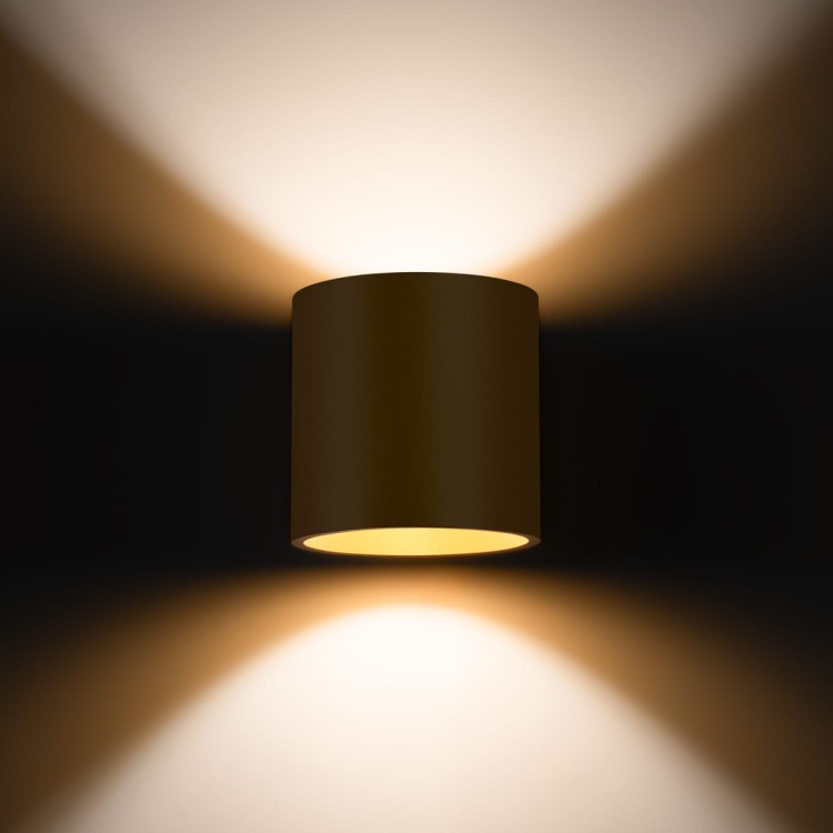 Kinkiet ORBIS Sollux SL.1181 to połączenie minimalistycznej formy i eleganckiego złotego wykończenia. Światło emitowane w górę i w dół subtelnie podkreśla charakter wnętrza i tworzy przytulny klimat.