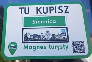 Magnes Turysty SIENNICA 05-332 przedstawia zabytki i budynki Siennicy w formie znaku „teren zabudowany”. Wykonany w 100% z biodegradowalnego materiału, wymiary 8,5×6,5 cm. Produkt polski, idealny na pamiątkę lub do kolekcji
