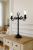 Klasyczna lampa stołowa LEMIR 388 L2 CZA w formie świecznika, wykonana ze stali i ZnAl, w matowej czerni. 2xE14 max 60W, włącznik na przewodzie, IP20. Idealna do eleganckich wnętrz: salonu, sypialni, gabinetu. Styl, jakość i ponadczasowy design