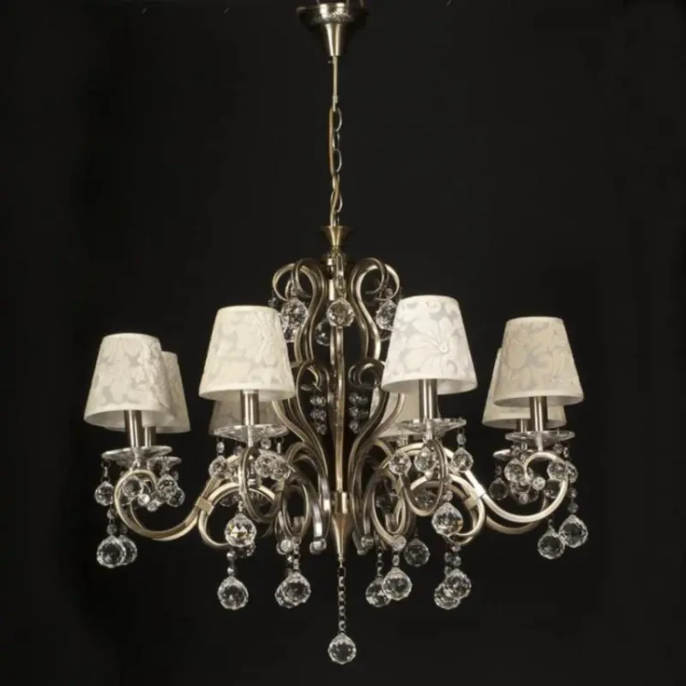 Żyrandol FLORENCE 8xE14 w stylu glamour to elegancka lampa do salonu z dekoracyjnymi abażurami ecru i kryształkami w formie kulek. Wykończenie w kolorze patyny podkreśla klasyczny charakter. Średnica 66 cm, wysokość 98 cm z możliwością skrócenia