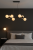 Stylowa lampa wisząca RADDI 6x5W Italux – czarna konstrukcja z matowej stali, szklane białe klosze w formie kul.