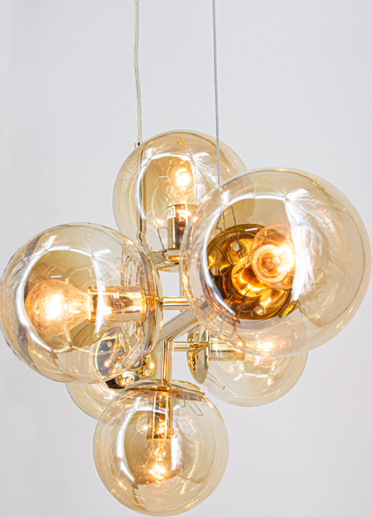Elegancka lampa sufitowa PACO 6xE14 złota z bursztynowymi kloszami. Idealna do wnętrz typu modern, scandi i glamour. Pięknie oświetla przestrzeń nad stołem lub wyspą kuchenną. Trwała konstrukcja z metalu i szkła. Regulowana wysokość 40–98 cm.