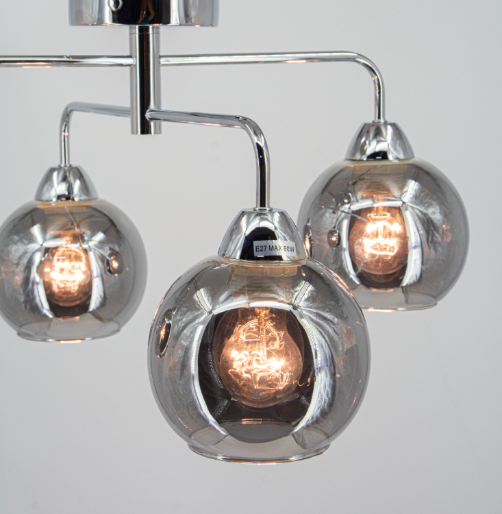 Połączenie chromu i dymionego szkła nadaje lampie ASPEN 4xE27 wyjątkowego charakteru. Model idealny do oświetlenia salonu, jadalni czy sypialni. Cztery punkty światła E27 gwarantują jasność i funkcjonalność. Wymiary: 57×30 cm.