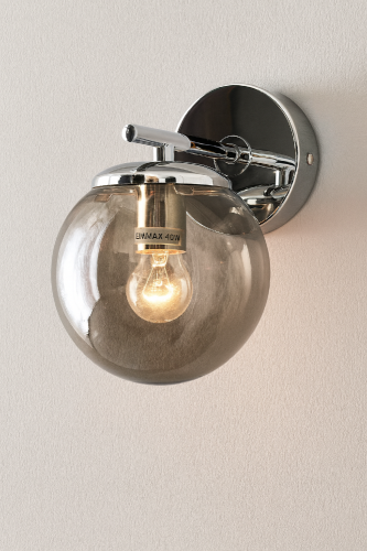 Kinkiet ERICE 1xE14 chrom 8491/1 8C to elegancka oprawa ścienna z dymionym, szklanym kloszem. Wymiary 20 × 20 cm sprawiają, że idealnie pasuje do salonu, sypialni i korytarza. Nowoczesny design świetnie uzupełnia wnętrza glamour i modern classic.