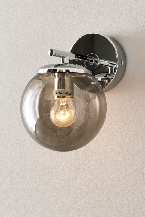 Kinkiet ERICE 1xE14 chrom 8491/1 8C to elegancka oprawa ścienna z dymionym, szklanym kloszem. Wymiary 20 × 20 cm sprawiają, że idealnie pasuje do salonu, sypialni i korytarza. Nowoczesny design świetnie uzupełnia wnętrza glamour i modern classic.