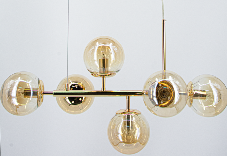 Lampa wisząca PACO 6xE14 w kolorze złotym z bursztynowym szkłem. Idealna do nowoczesnych, przytulnych wnętrz. Doskonała nad stół, wyspę lub do salonu. Ociepla wnętrze i dodaje mu luksusowego charakteru. Modny styl modern–glam