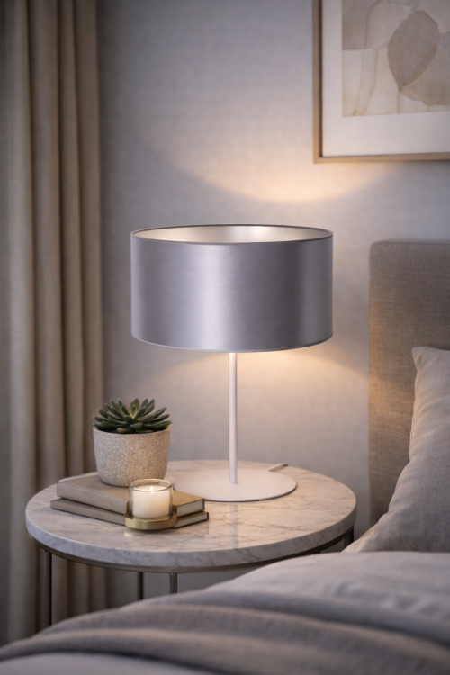 Biała lampa stołowa CANNES 1xE14 to stylowy dodatek do wnętrz nowoczesnych i skandynawskich. Atłasowy abażur z srebrnym wnętrzem subtelnie odbija światło, tworząc przytulny i elegancki klimat.
