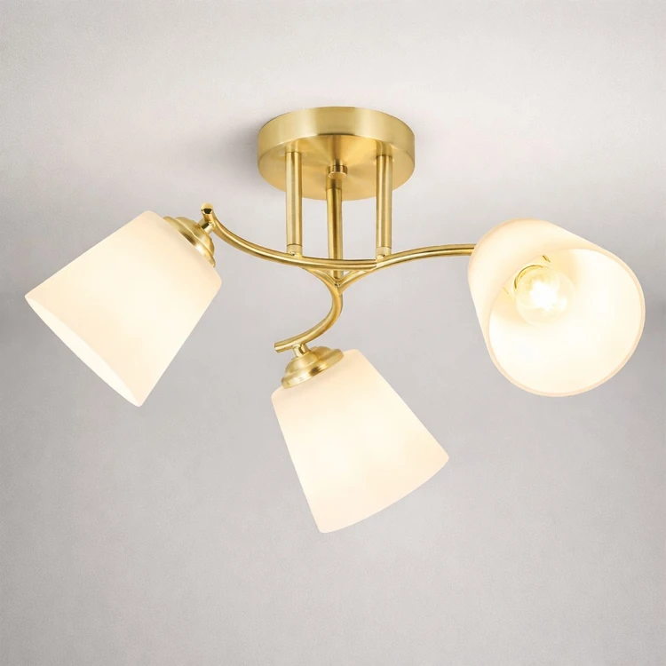 Lampa Pafos 3xE27 to nowoczesne oświetlenie sufitowe w złotym kolorze. Trzy klosze z białego szkła równomiernie rozpraszają światło, tworząc przytulną atmosferę w salonie, sypialni lub korytarzu.