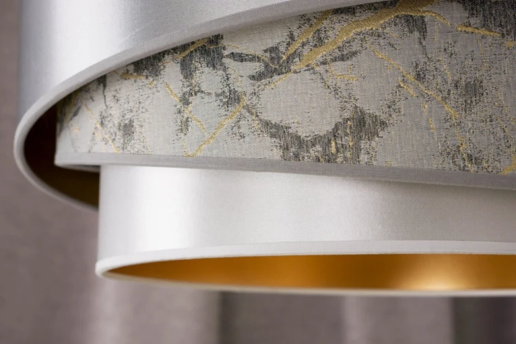 Stylowa lampa sufitowa KOBO 1xE27 łączy modny motyw marmuru z subtelnymi tkaninami. Dzięki złotemu wnętrzu klosza światło staje się ciepłe i przytulne, tworząc wyjątkową atmosferę w każdym pomieszczeniu.