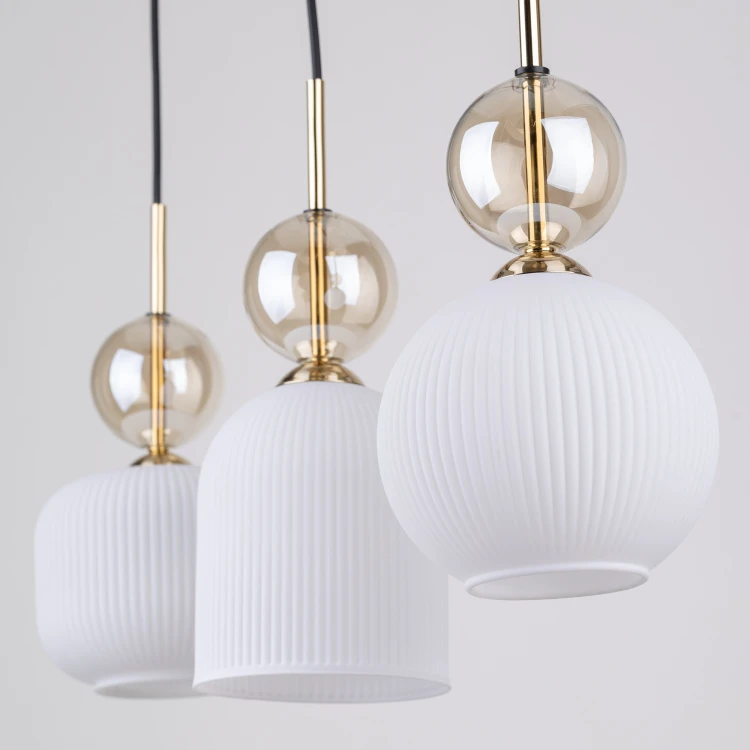 Lampa wisząca SOPHIA Cognac została stworzona z myślą o stylowych wnętrzach. Białe ryflowane klosze pięknie rozpraszają światło, a dekoracyjne kule cognac nadają całości luksusowego i ponadczasowego wyglądu