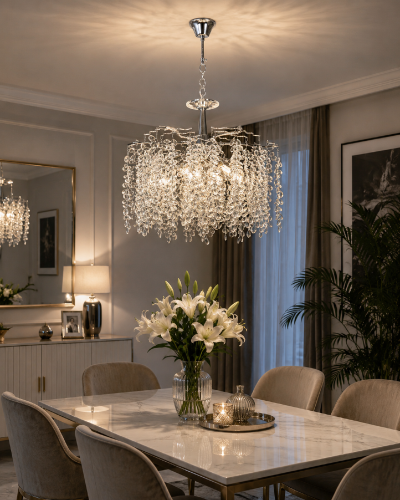 Żyrandol FLORES chrom 6xE14 to połączenie nowoczesnej elegancji i dekoracyjnego blasku. Szklane zawieszki tworzą lekką, efektowną kompozycję, która doskonale podkreśla charakter wnętrz glamour i modern classic.