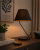 Stylowa lampka stołowa VICTORIA BLACK Milagro zachwyca ponadczasowym designem. Czarna tkanina i metalowa podstawa doskonale komponują się z wnętrzami glamour, loft i modern classic. Idealna na stolik nocny lub komodę