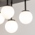 Lampa sufitowa TULIA 6xG9 czarna z białymi kloszami efektownie oświetli salon, jadalnię, sypialnię lub korytarz. Sześć szklanych kul umieszczonych na prętach o różnej długości tworzy ciekawą, przestrzenną kompozycję.