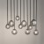 TULIA 10xG9 to nowoczesna lampa sufitowa z czarną, matową podsufitką i dymionymi kloszami ze szkła. Model o wymiarach 75 × 19 × 90 cm pasuje do przestronnych jadalni, wysokich salonów, antresoli i holi.