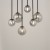 TULIA 6xG9 to nowoczesna lampa sufitowa z czarną, matową podsufitką i dymionymi kloszami ze szkła. Model o wymiarach 42 × 19 × 90 cm pasuje do wysokich salonów, antresoli, holi, jadalni i klatek schodowych.