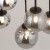 Czarna lampa sufitowa TULIA 6xG9 Sigma ma sześć dymionych kul, które tworzą nastrojowy efekt świetlny. Długie pręty układają klosze w kaskadę. Model sprawdzi się nad stołem, wyspą lub barkiem oraz w wysokich wnętrzach.