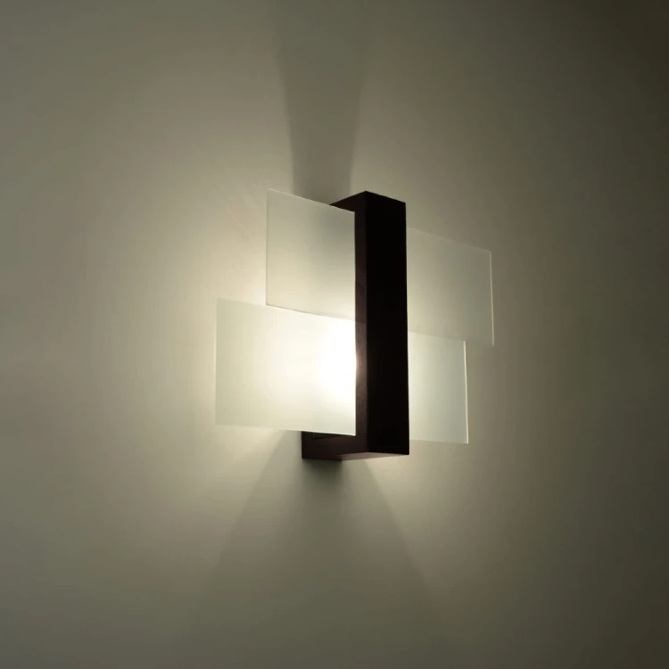 FENIKS Sollux SL.0075 to elegancki kinkiet wykonany z ciemnego drewna wenge oraz szkła. Lampa subtelnie rozprasza światło i pasuje do salonu, jadalni, gabinetu lub korytarza. Źródło światła 1 × E27 nie znajduje się w komplecie.