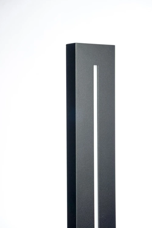 Pionowy kinkiet zewnętrzny LANGER LGM-1010 wyróżnia się smukłą obudową i świetlnym paskiem LED z przodu. Lampa ma 101 cm wysokości, moc 26 W, strumień oprawy 1000 lm i barwę 4000 K. Aluminiowa konstrukcja, IP65.