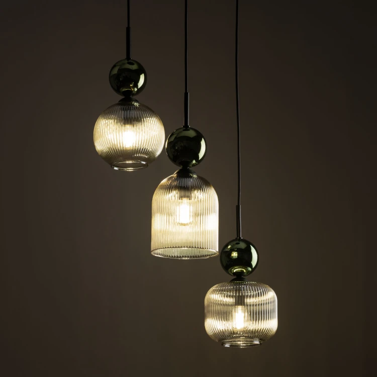 Dekoracyjna lampa SOPHIA 11147 z trzema różnymi kloszami z koniakowego szkła. Podłużna konstrukcja równomiernie oświetla stół lub wyspę, a zielone szklane kule podkreślają elegancki styl glamour.